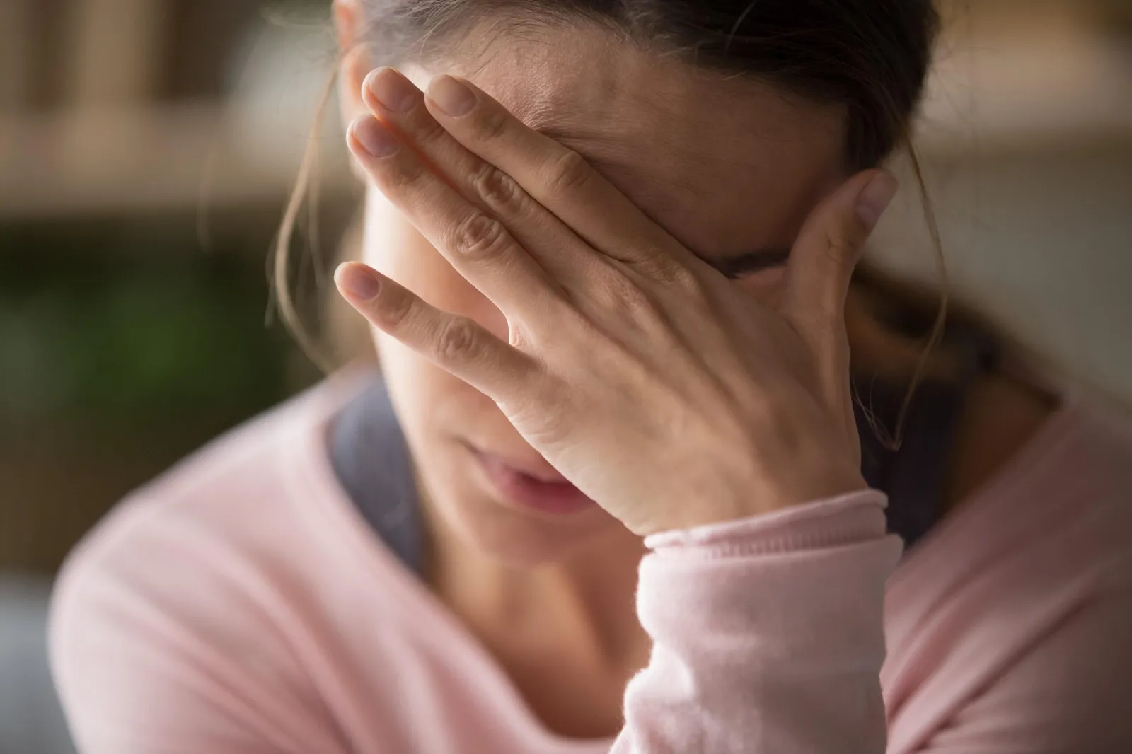 Mujer cubriéndose el rostro con la mano por la ansiedad, antes de buscar un psicólogo para la ansiedad en Escazú