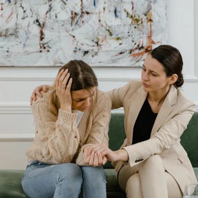 Psicóloga consolando a una mujer angustiada durante una sesión de terapia para la depresión